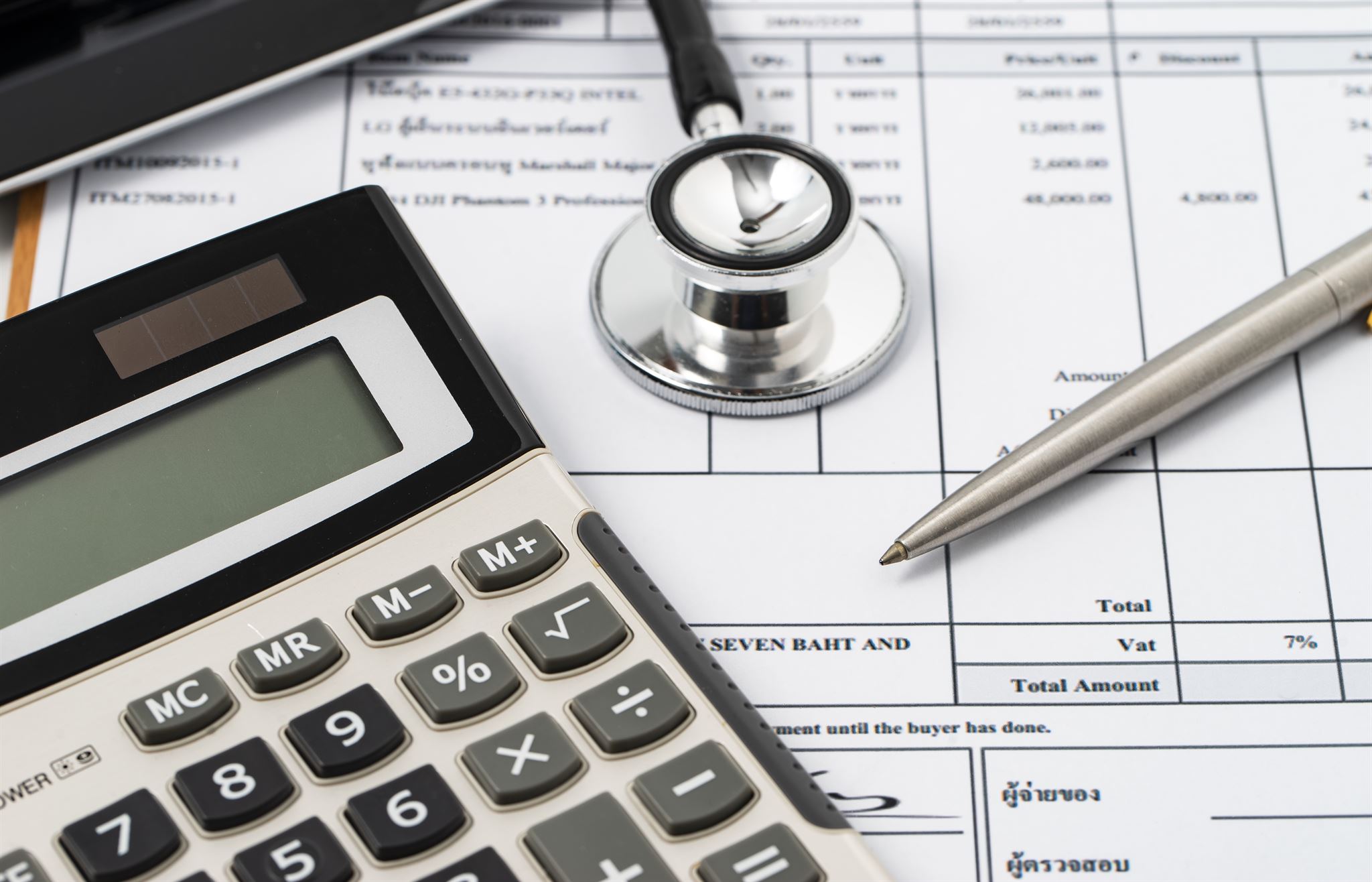 close-up-of-calculator-and-stethoscope-placed-on-invoice